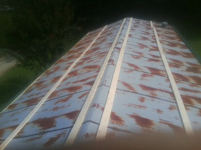 Rusted metal roof panels with new wood purlins before replacement — Storm Damage Roof Repair in Bluewater by Roofing Brothers