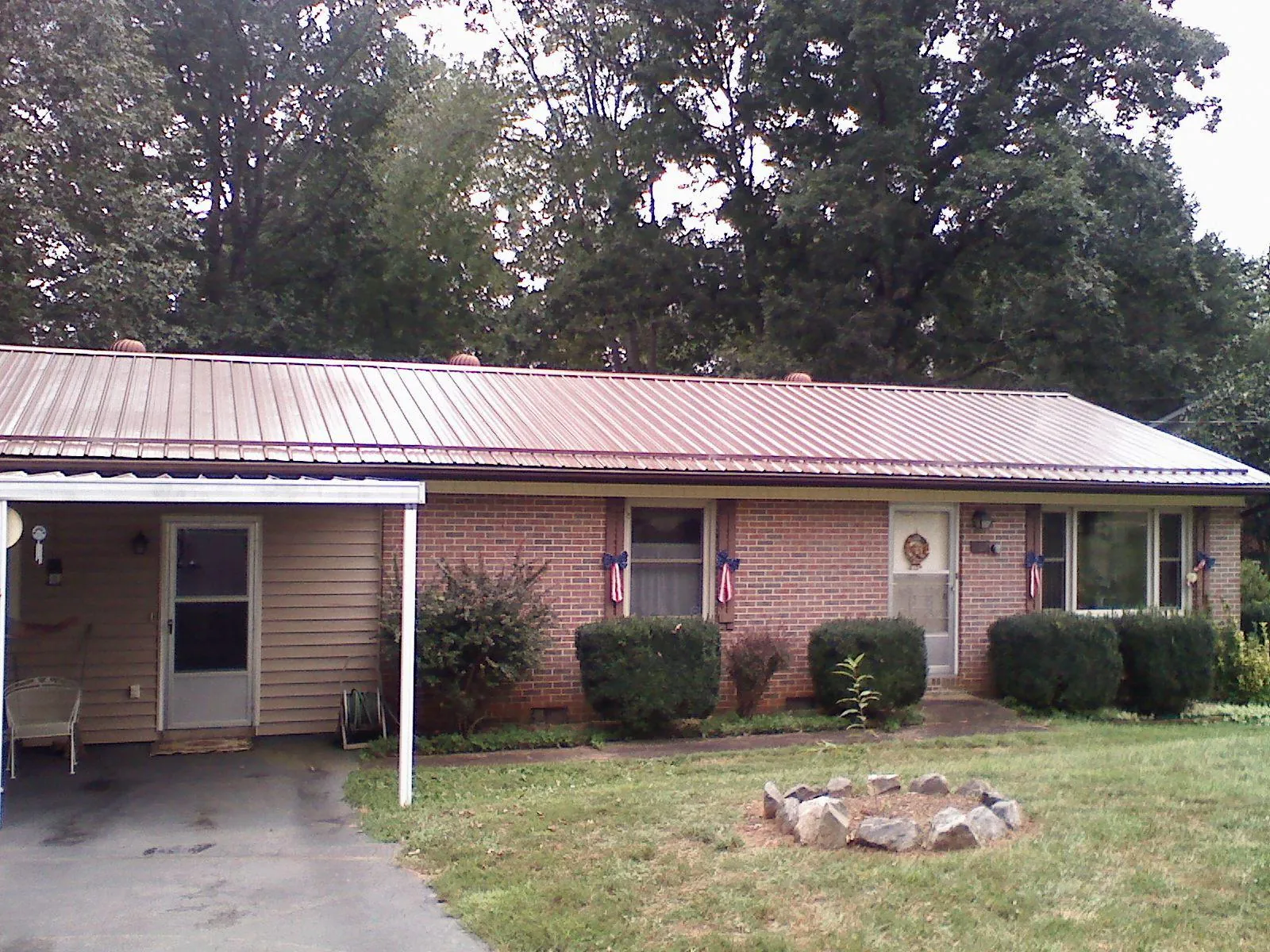 Bronze metal roof and carport on a brick ranch home — Roof Repair work by our crew in Bluewater