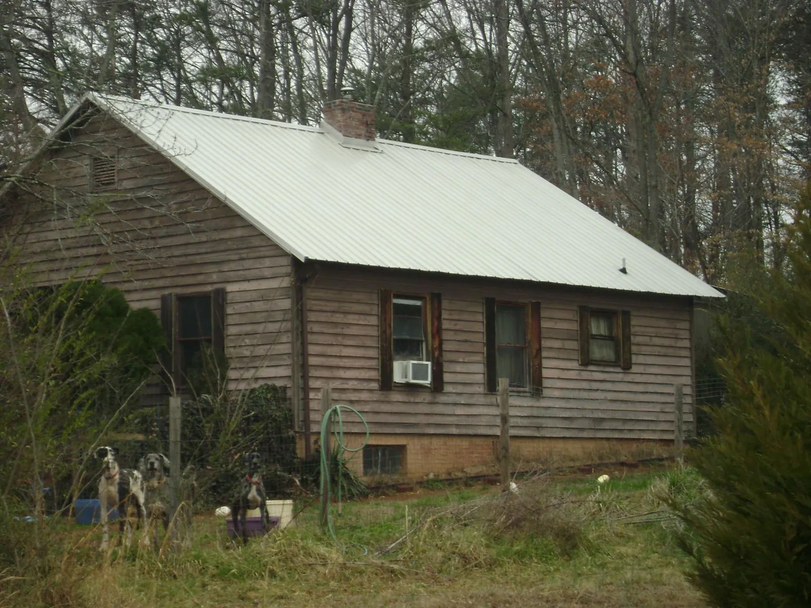 White metal roof on an old wood sided farmhouse, from a Metal Roof Installation job in Bluewater